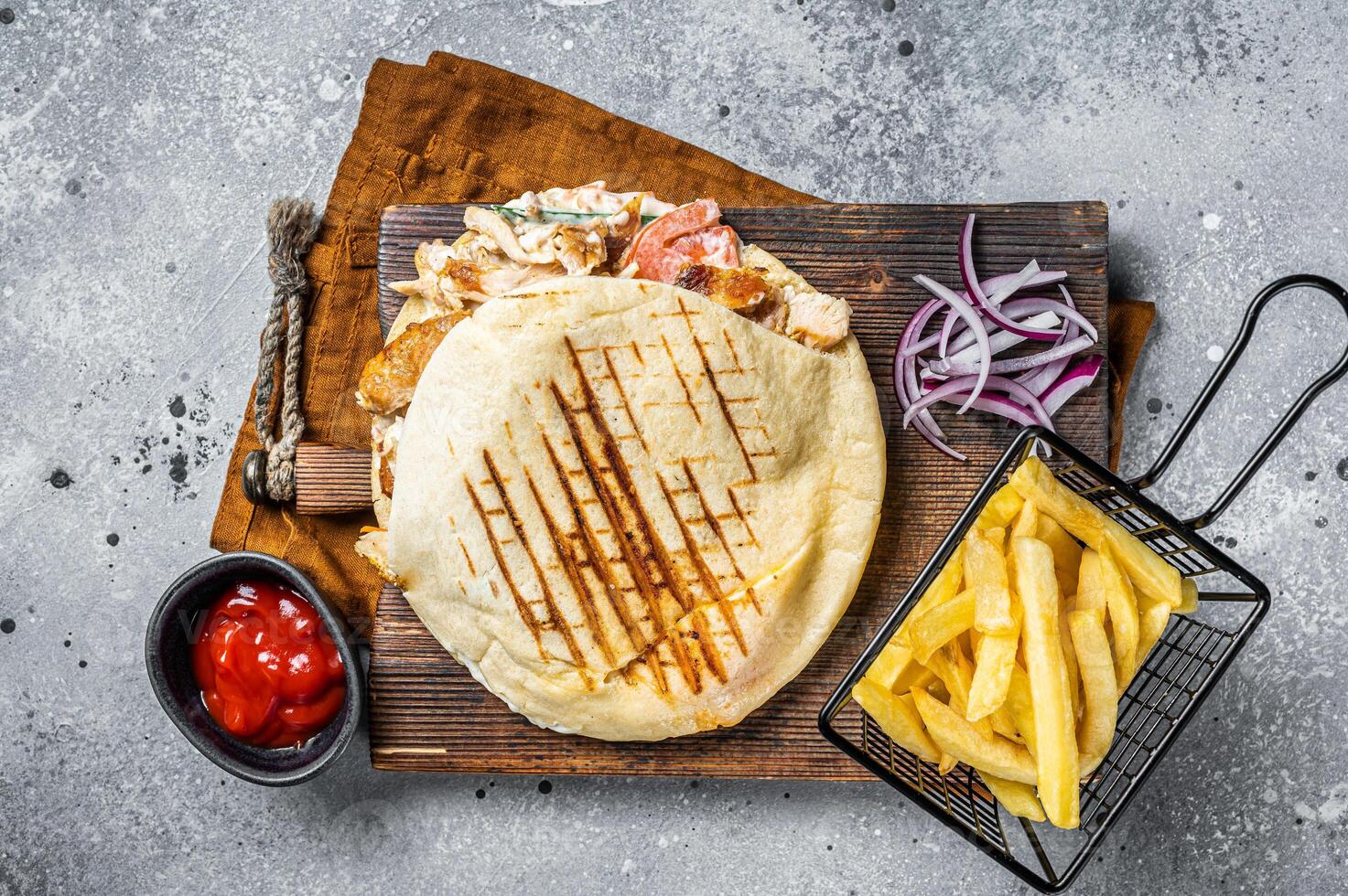Doner kebab, Shawarma in grilled pita bread with vegetables and meat. Gray background. Top view photo