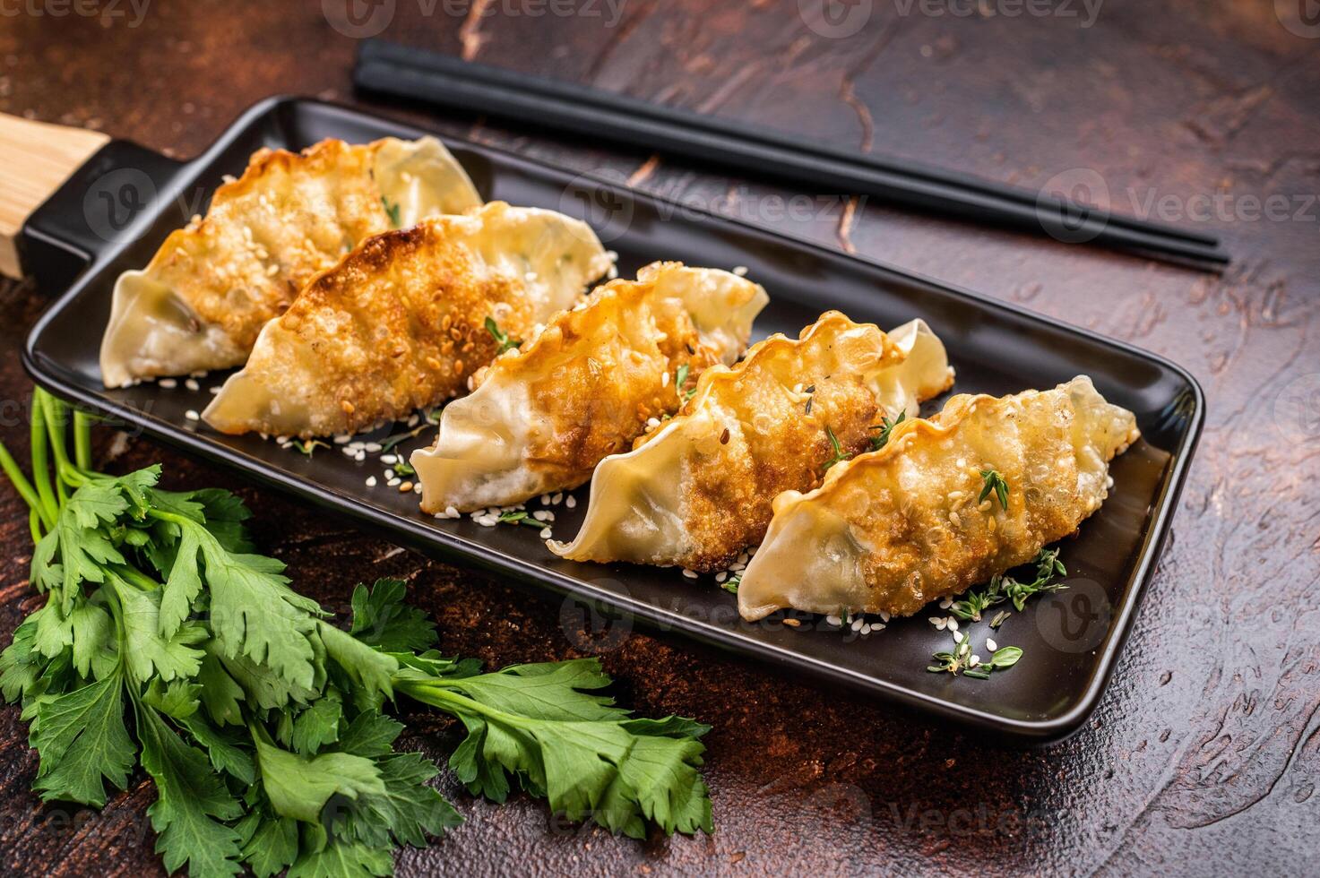 Fried Korean Dumplings on plate with sauce, Dumplings with shrimps and vegetables. brown background. top view photo