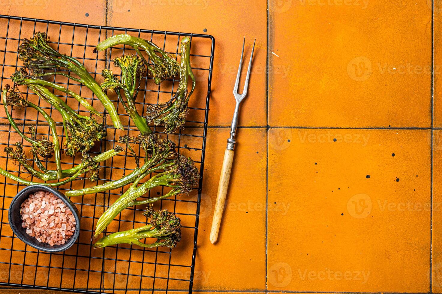 Grilled Broccolini Sprouts with garlic. Orange background. Top view. Copy space photo