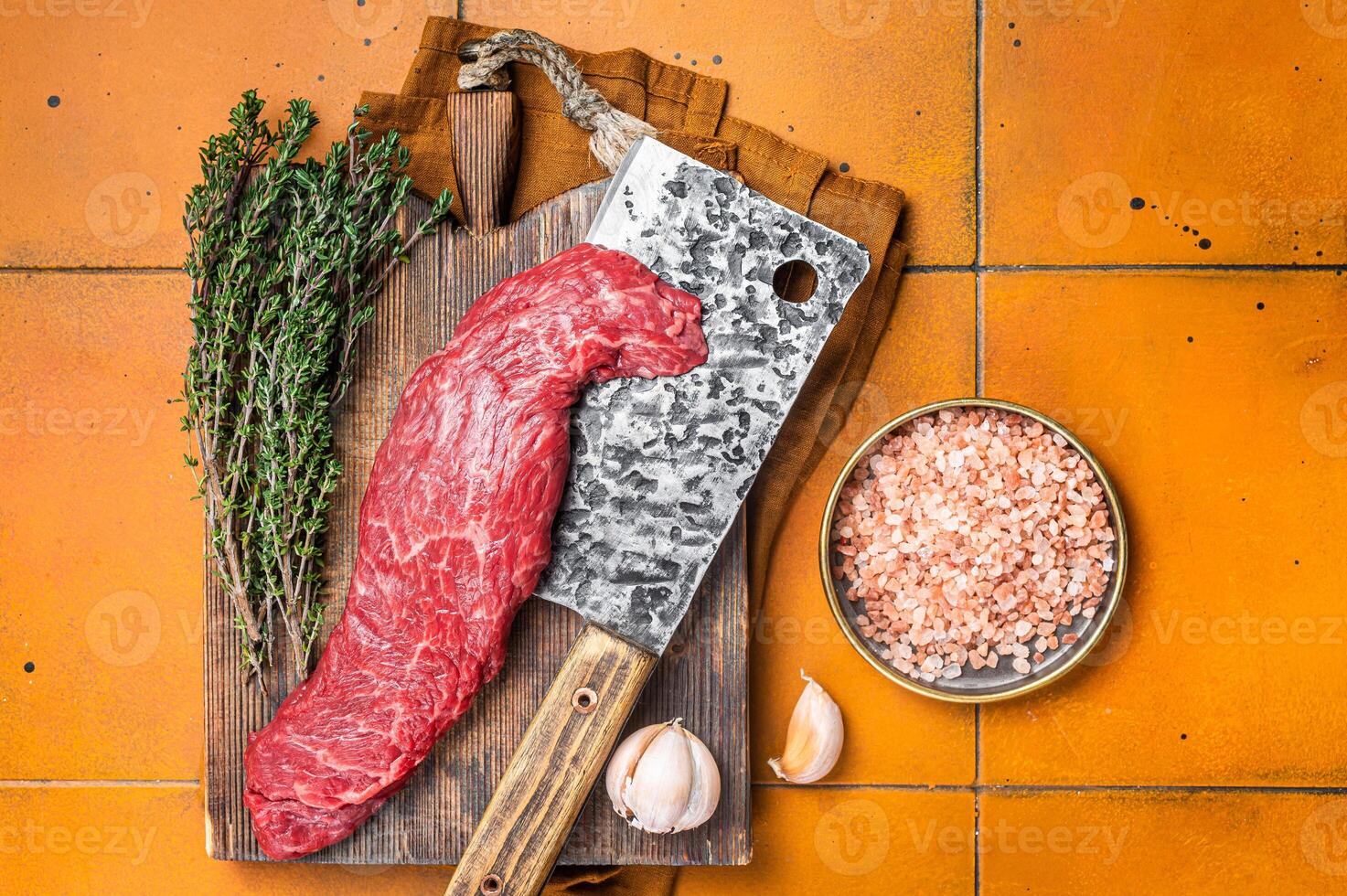 Fresh Raw Machete beef meat steak or hanging tender cut on butcher cutting board. Orange background. Top view photo