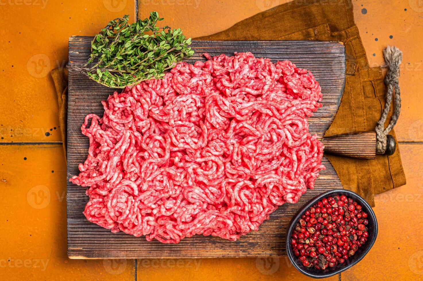 Fresh Raw Mince, Ground beef and pork meat on a butcher board. Orange background. Top view photo