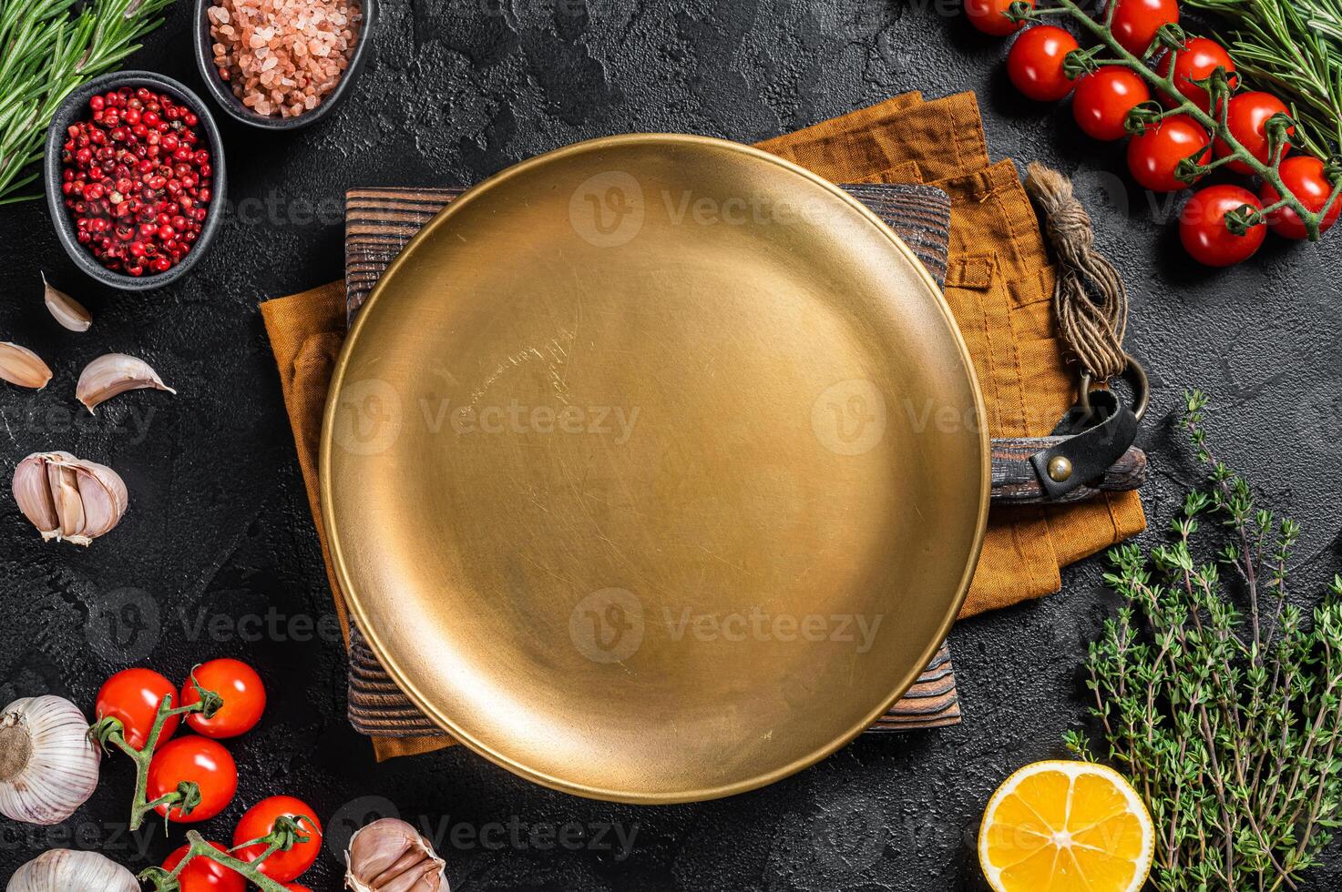 Healthy eating vegan food concept background with empty plate and fresh seasoning, herbs and ingredients. Black background. Top view. Copy space photo