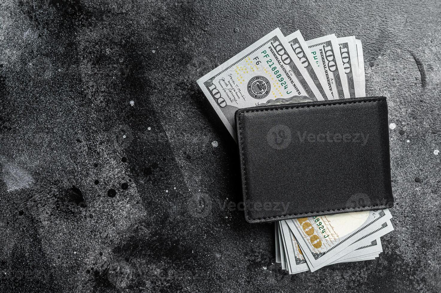 One black purse with the big pack of dollars, Cash of dollar note. Black background. Top view. Copy space photo