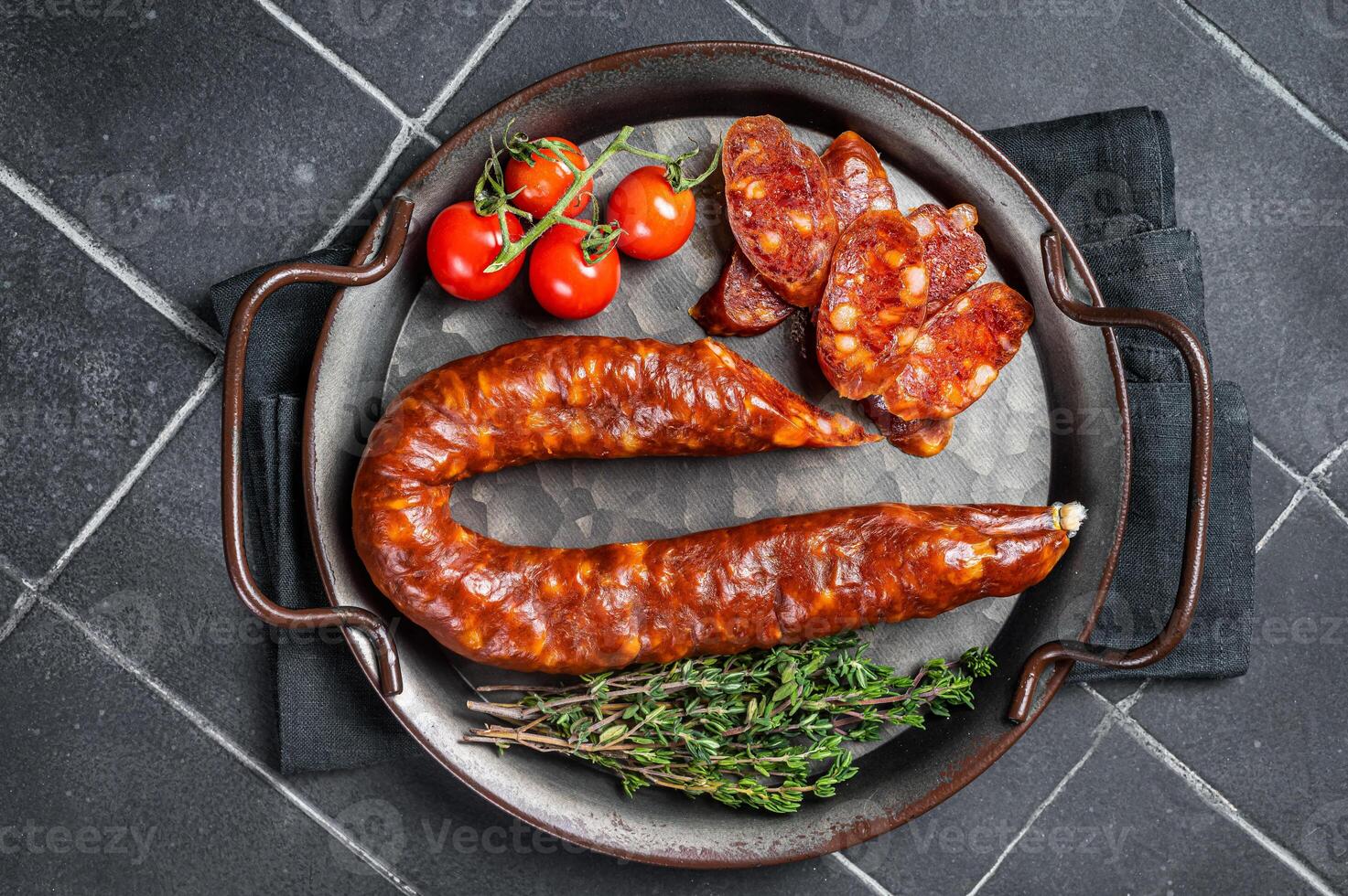 Sliced Chorizo sausage, slices of dry cured pork with herbs and spices. Black background. Top view photo