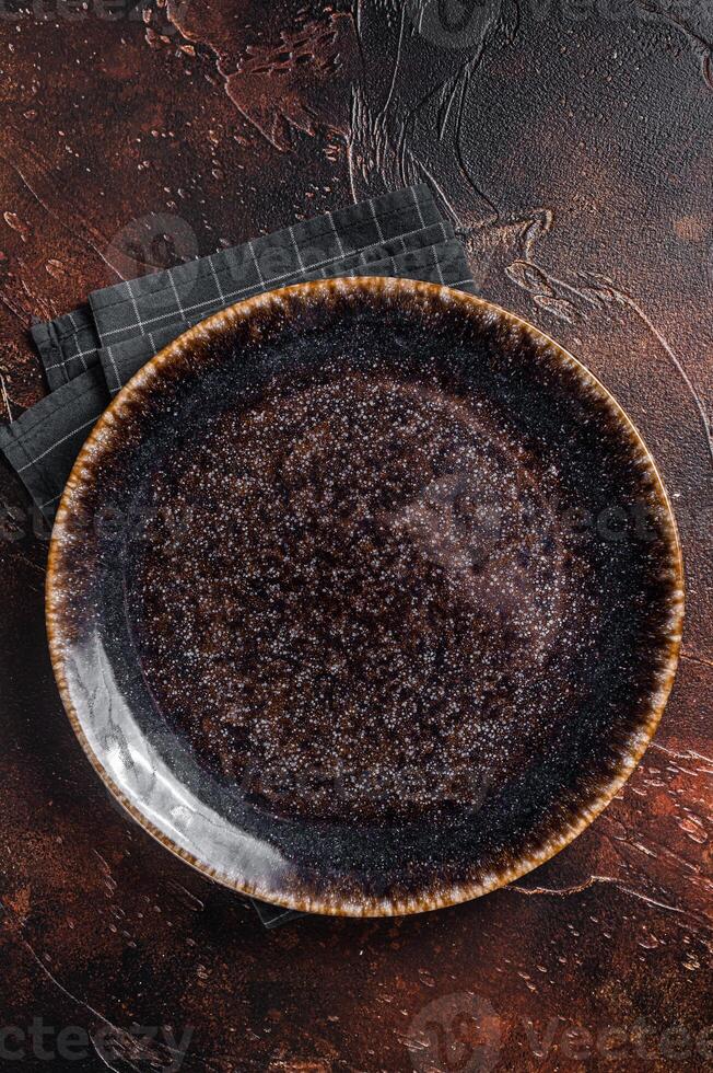 Table setting with vintage empty black plate on rustic wood. Dark background. Top view. Copy space photo
