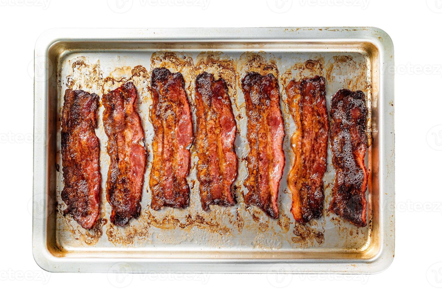 Strips of fried bacon in baking dish. Isolated on white background, top view. photo