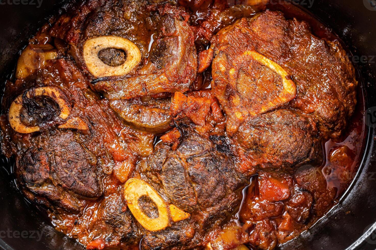 Osso buco cross cut veal shank braised with tomatoes and spices, beef meat Ossobuco. White background. Top view photo