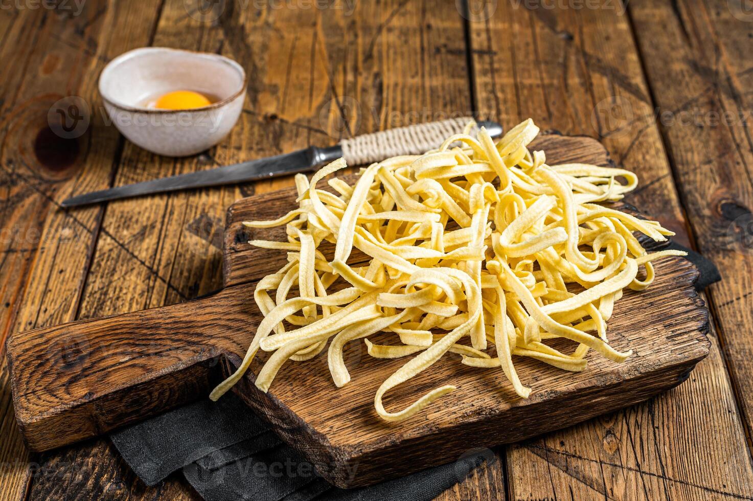 Cooking raw spaetzle egg noodle. Wooden background. Top view photo