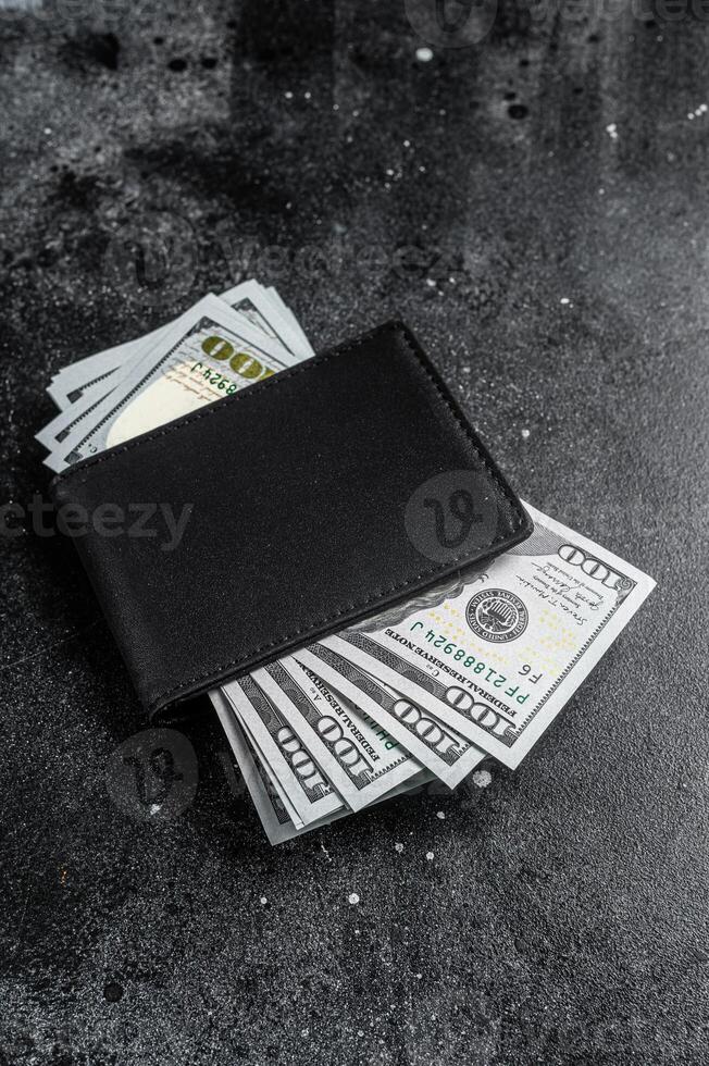 One black purse with the big pack of dollars, Cash of dollar note. Black background. Top view. Copy space photo