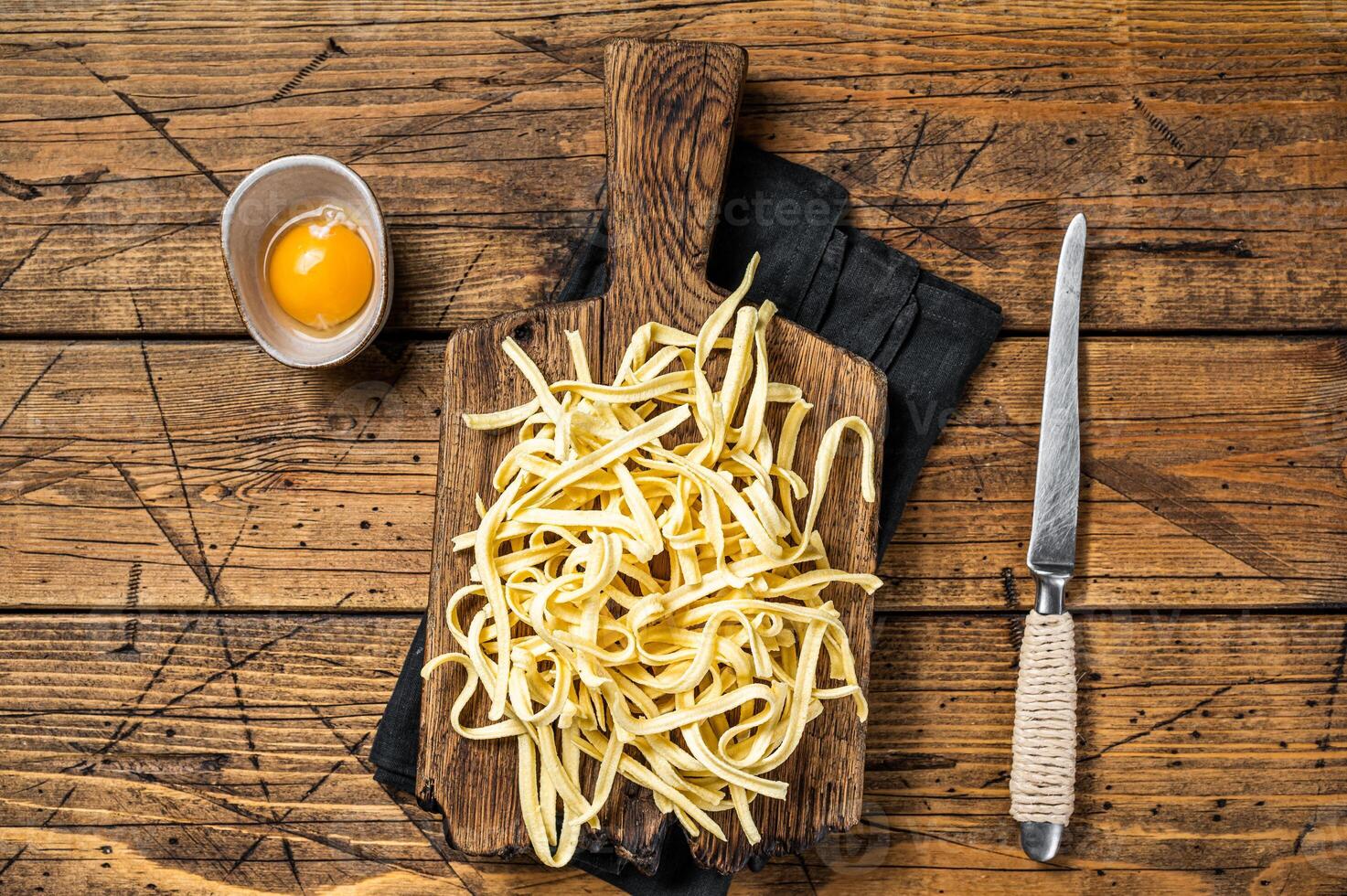 Cooking raw spaetzle egg noodle. Wooden background. Top view photo