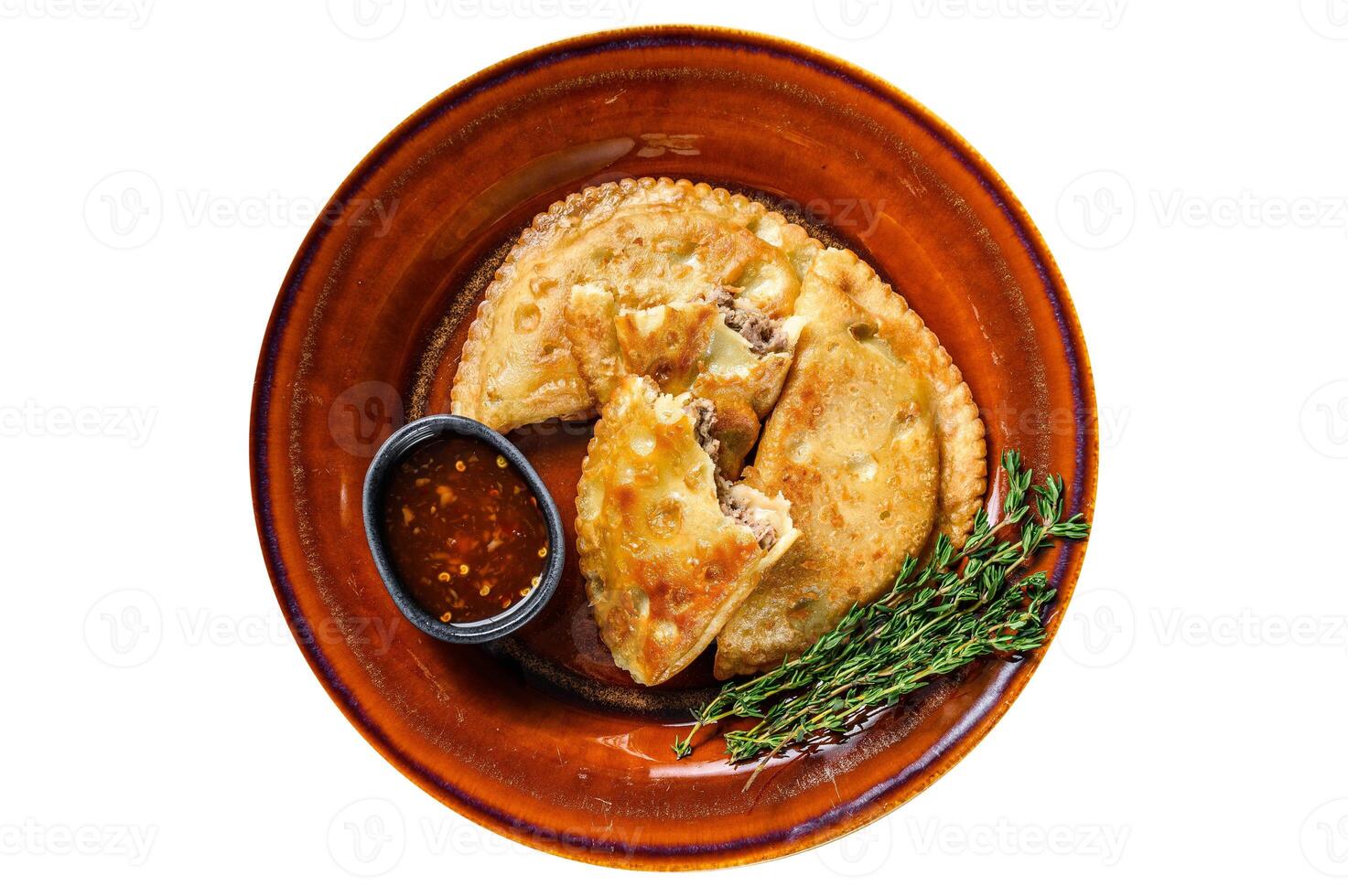 Fried empanadas with minced beef meat served on a plate with chili sauce. Isolated on white background. photo