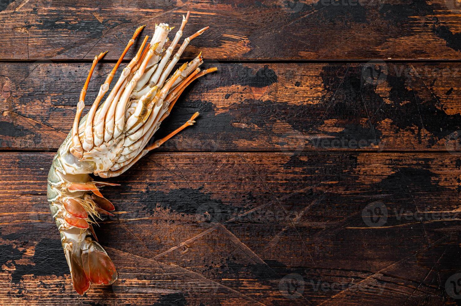 Fresh Spiny lobster on a wooden table, raw seafood. Wooden background. Top view. Copy space photo