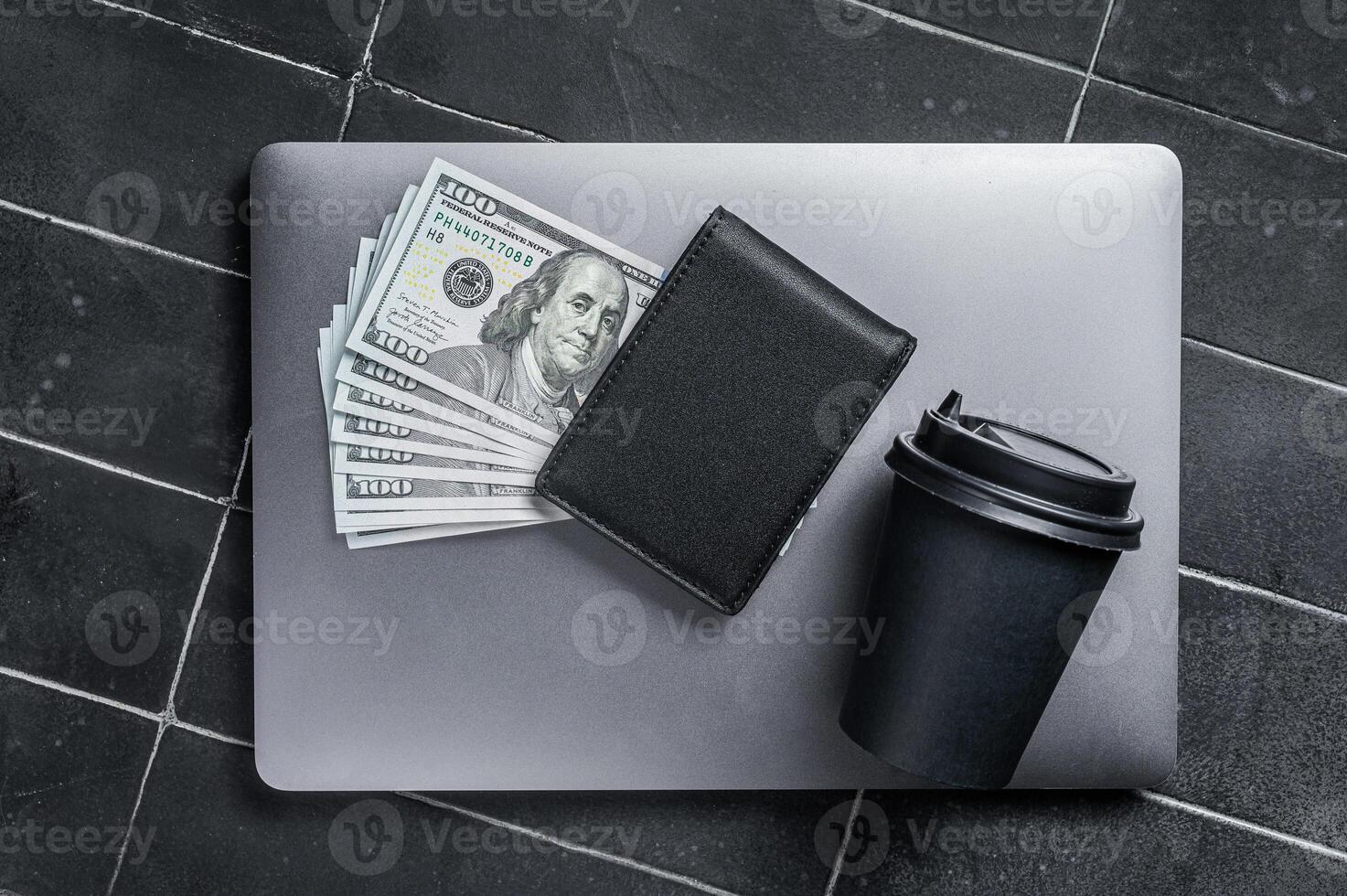 Corporate business desktop with laptop, digital tablet, wallet, money and cup of coffee. Black background. Top view. Copy space photo