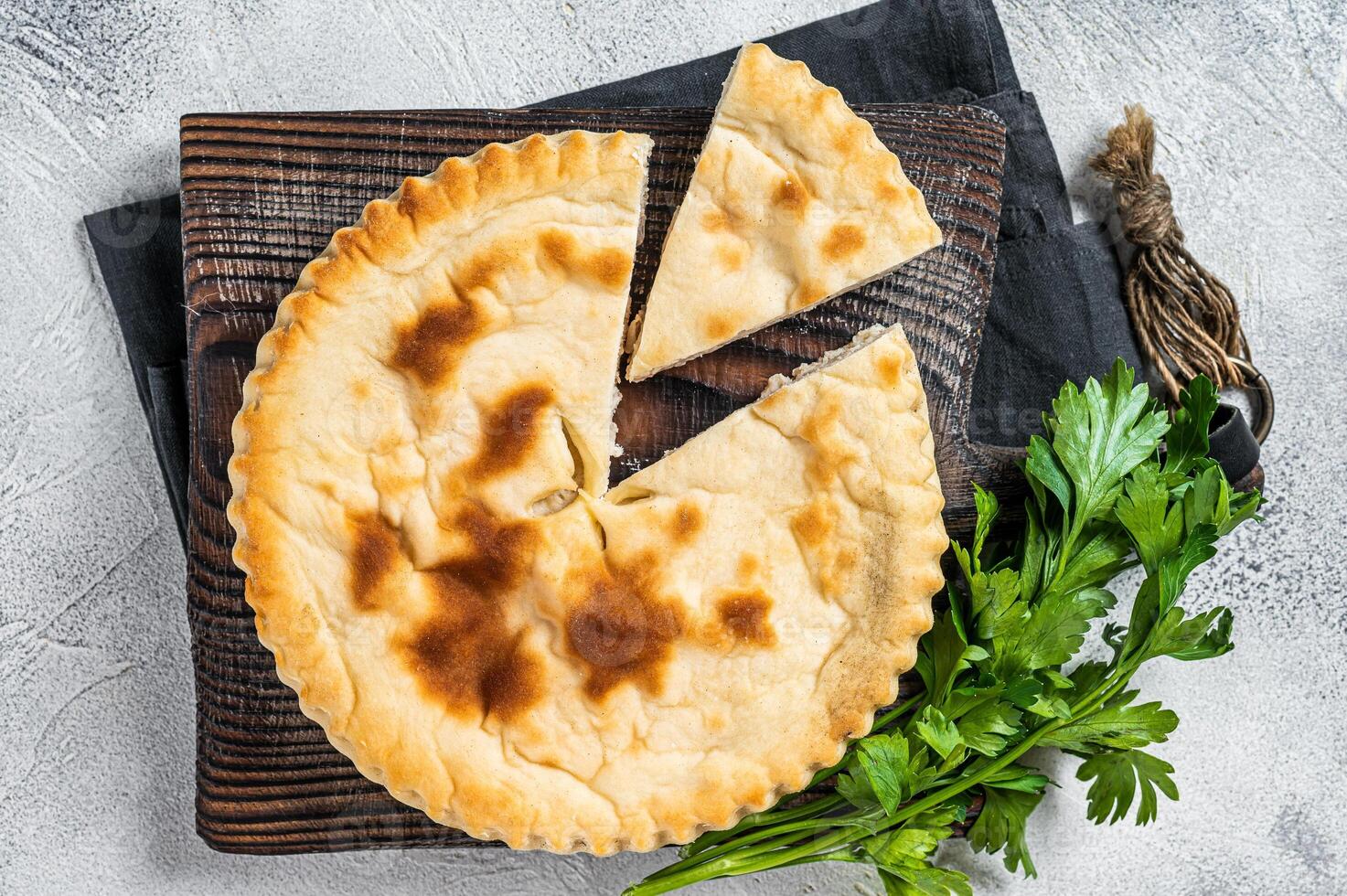 Sliced Kubdari, Tasty Georgian Flat Bread Stuffed with meat. White background. Top view photo