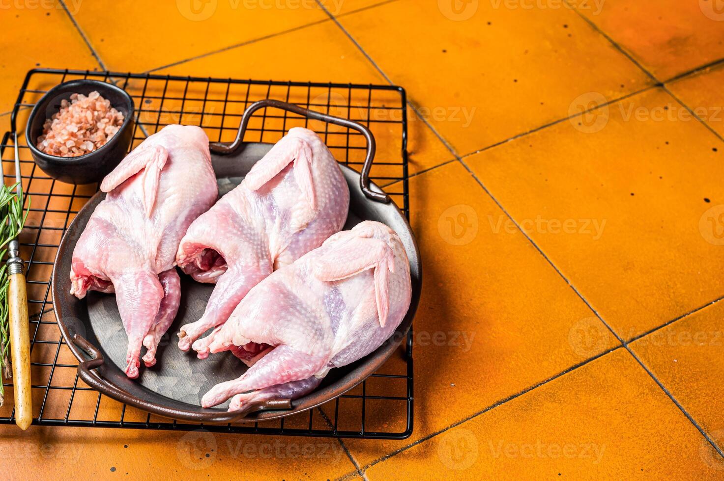 Raw whole quails ready for cooking. Orange background. Top view. Copy space photo