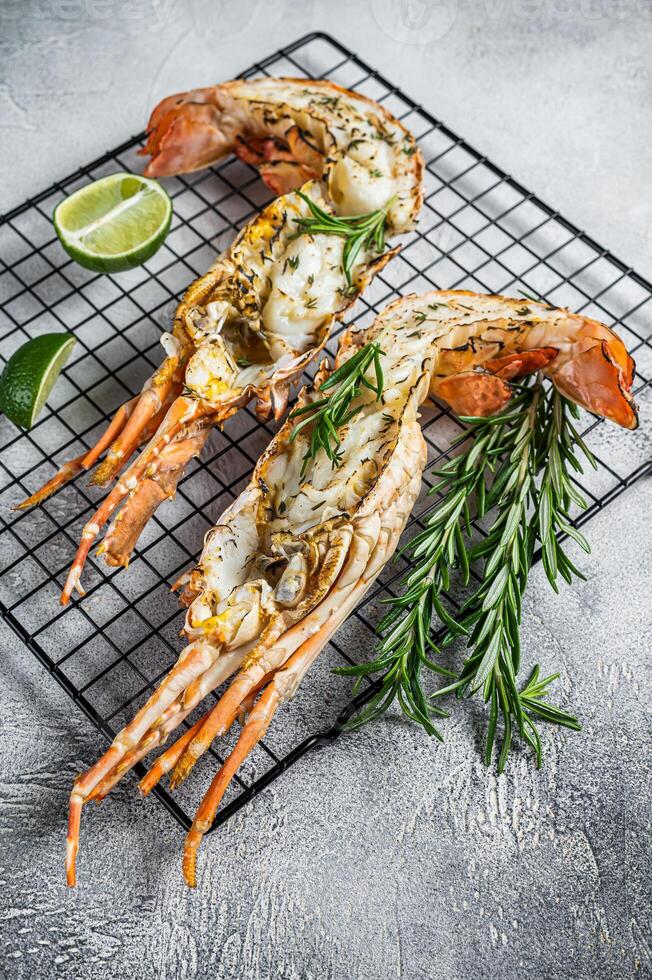Barbecue grilled and sliced Spiny lobster or sea crayfish with herbs. White background. Top view photo