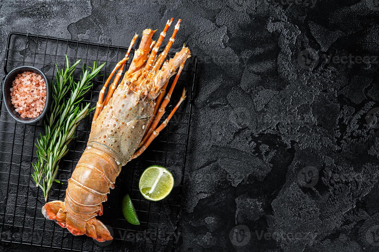 Boiled Spiny lobster or sea crayfish ready for eat. Black background. Top view. Copy space photo