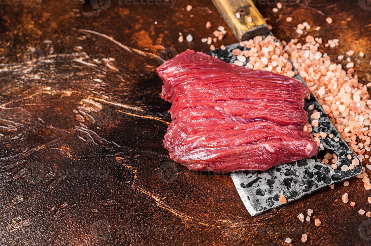 Butcher board with Raw Venison dear meat steak. Dark background. Top view. Copy space photo