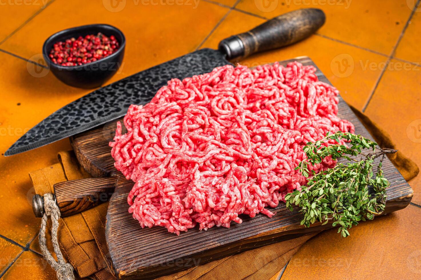 Fresh Raw Mince, Ground beef and pork meat on a butcher board. Orange background. Top view photo