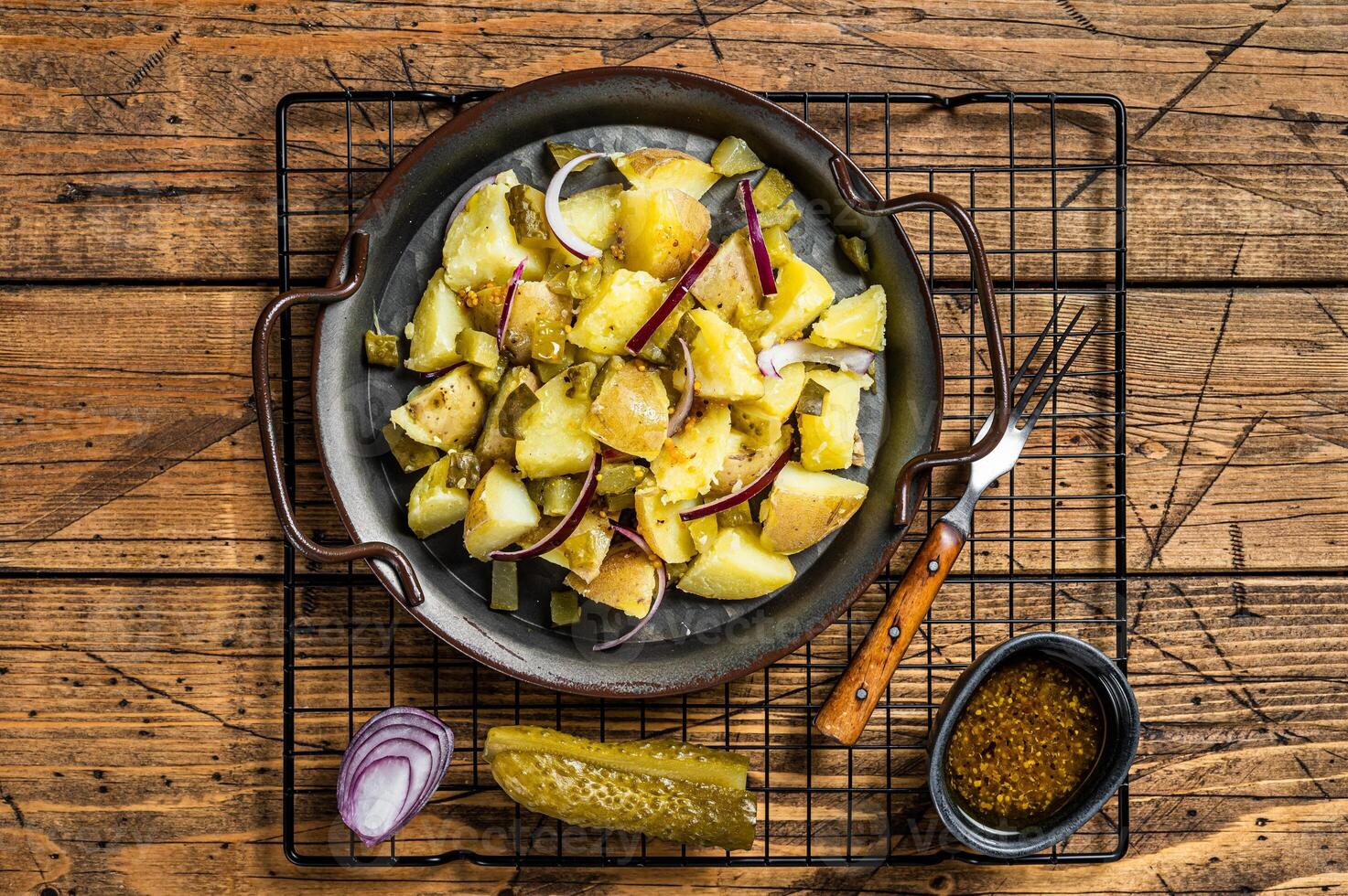 Kartoffelsalat - Traditional German potato salad. Wooden background. Top view photo