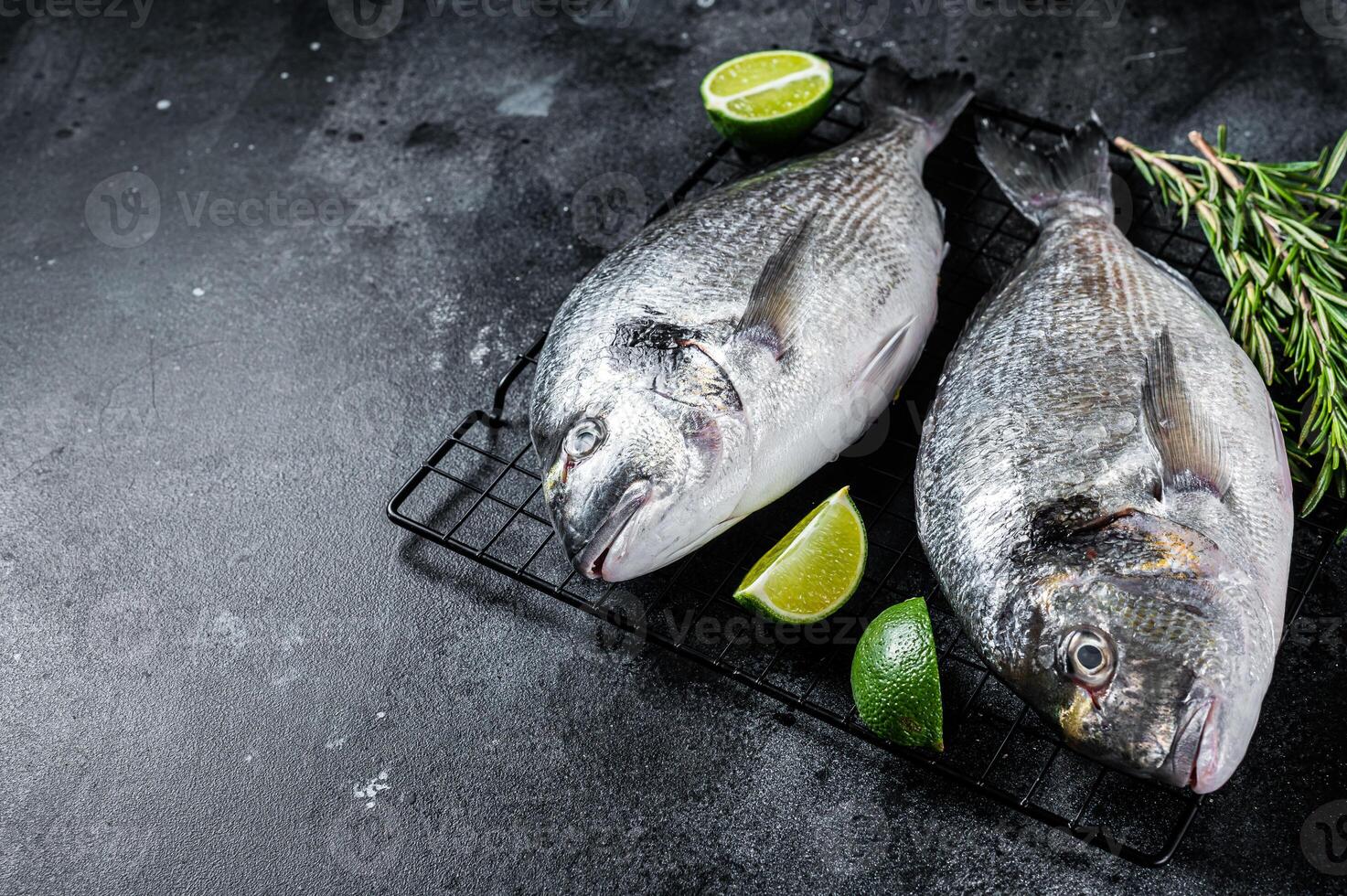 Raw sea bream dorado fish ready for cooking. Black background. Top view. Copy space photo