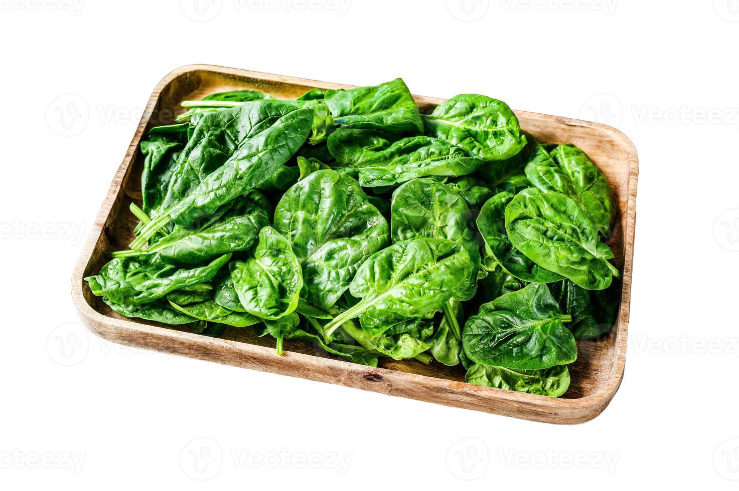 Young spinach leaves in a wooden bowl with goat cheese. Isolated on white background. Top view. photo
