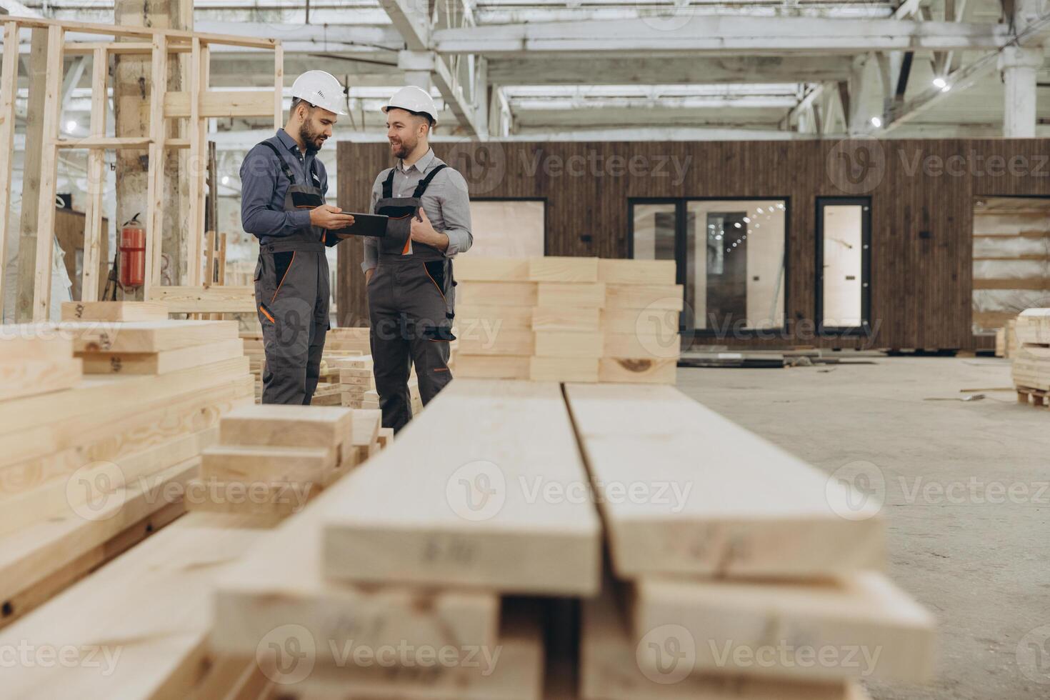 Construction workers discussing plans in modular building factory photo
