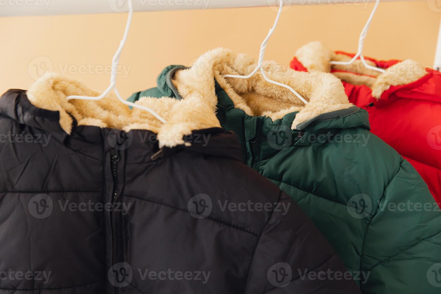Winter jackets hanging on rack, showing warm lining photo