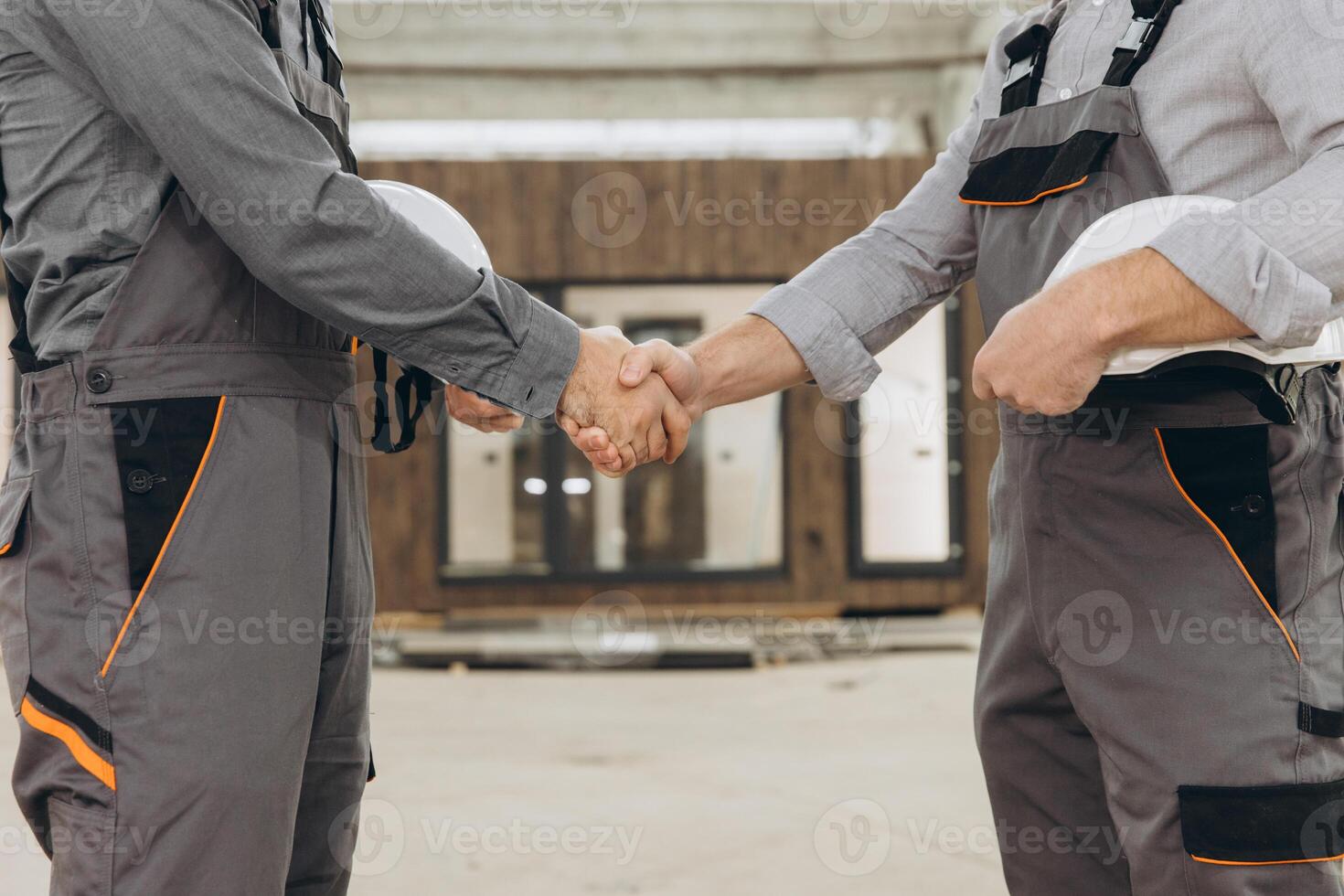 Construction workers shaking hands at modular building site photo