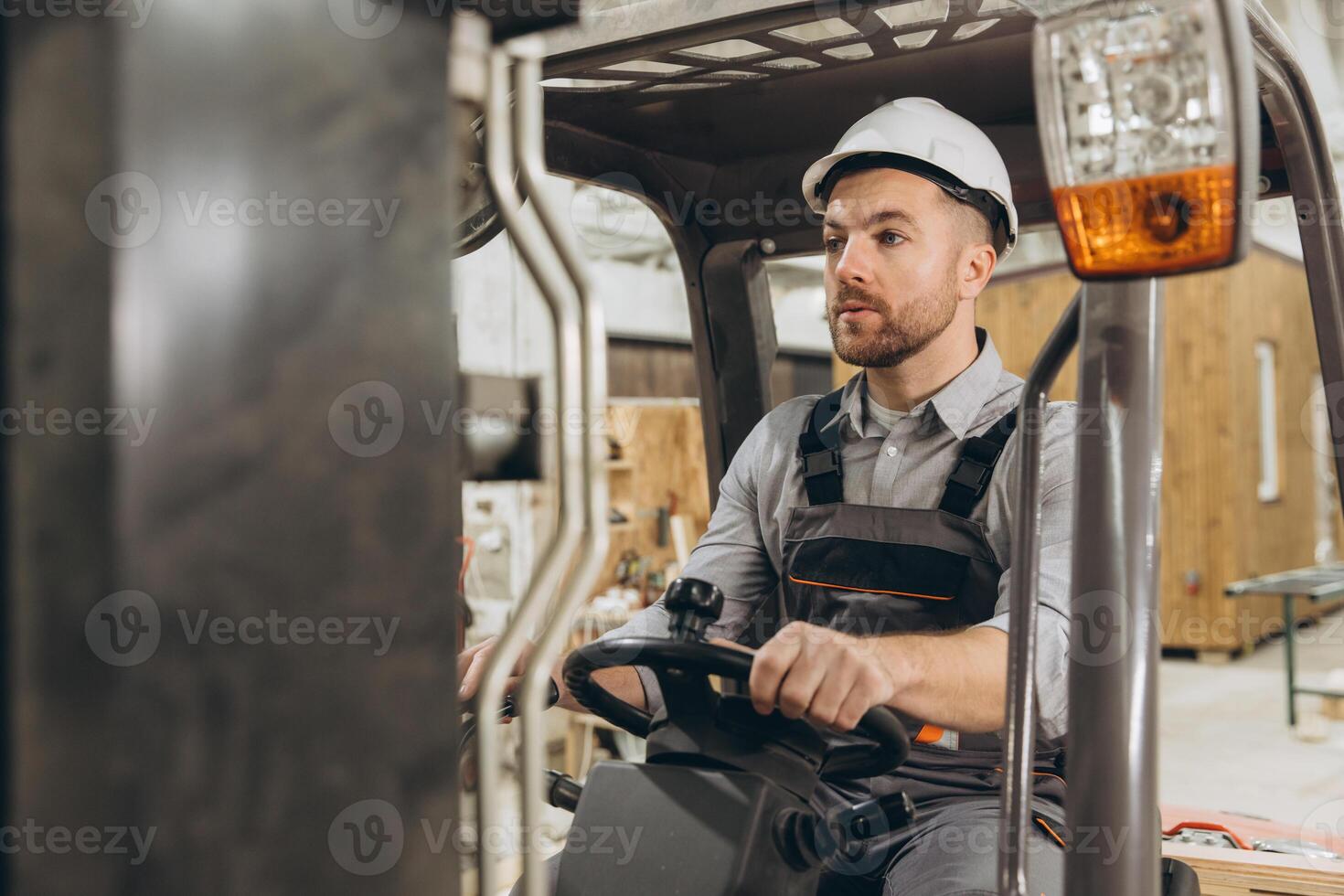 Warehouse worker driving forklift in modular building factory photo
