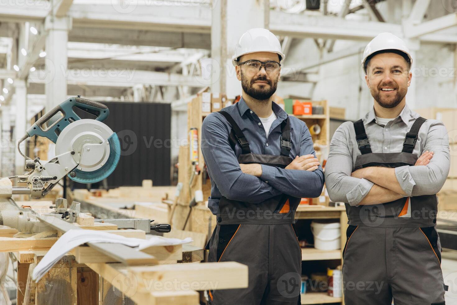 Construction workers smiling with arms crossed in modular building factory photo