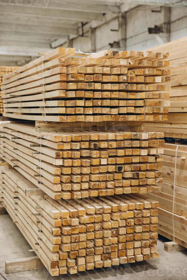 Stacks of square timber planks forming geometric pattern in lumber warehouse photo