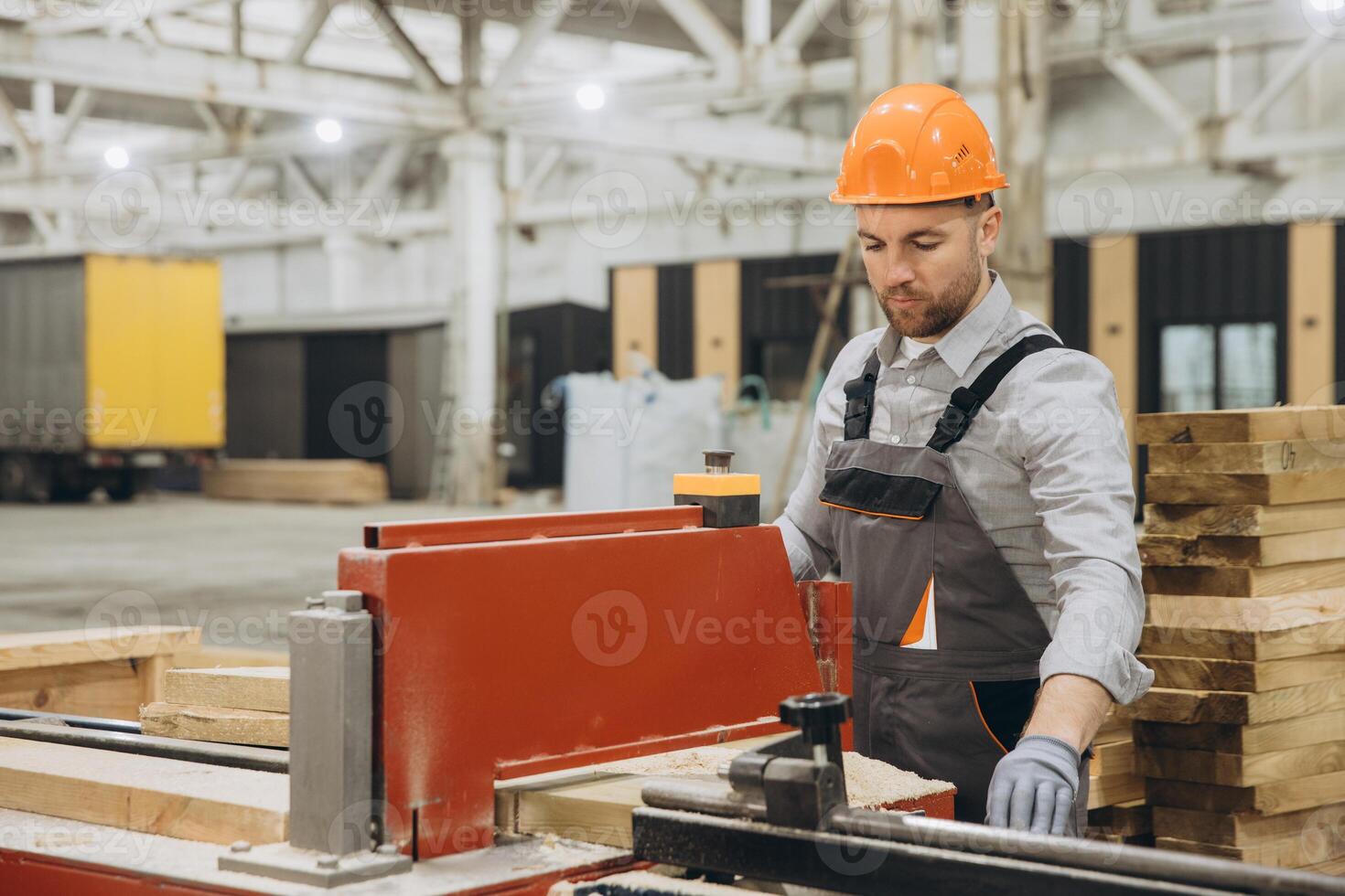 Carpenter cutting wooden planks in a factory for modular building industry photo