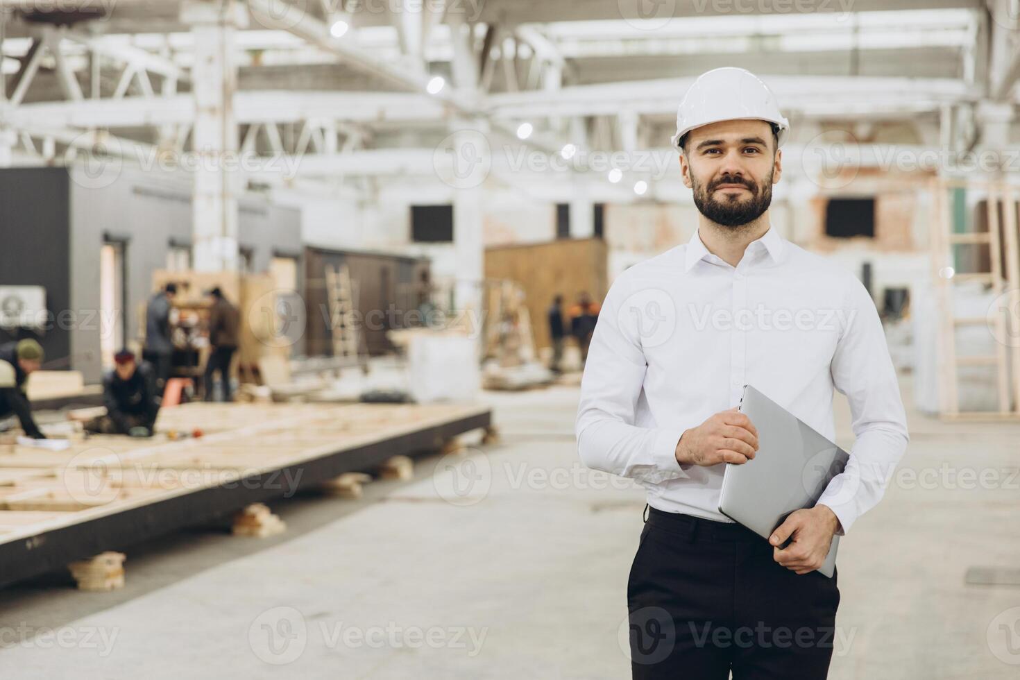 Engineer supervising prefabricated modular building construction in factory photo
