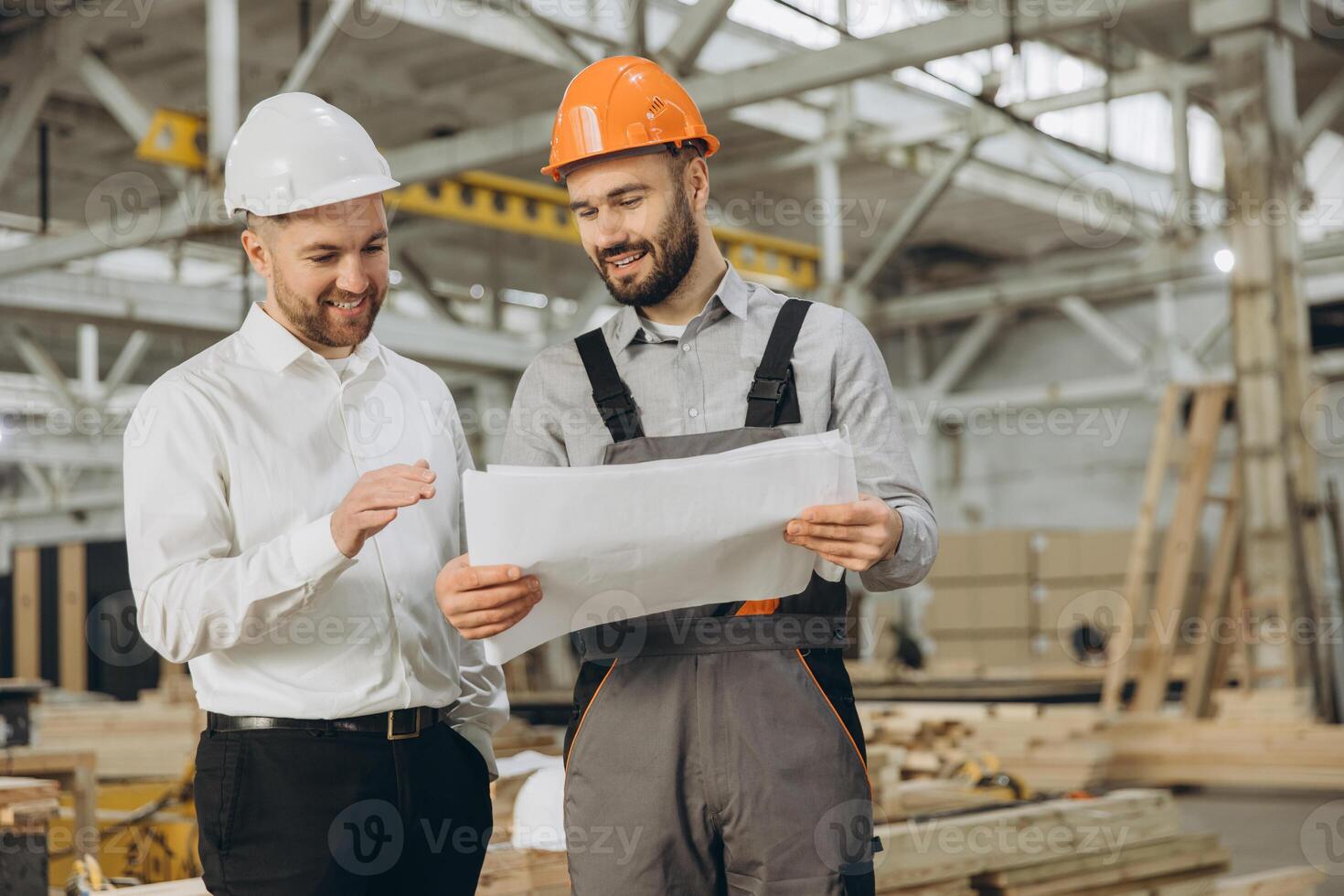 Engineers reading blueprint in modular building factory photo