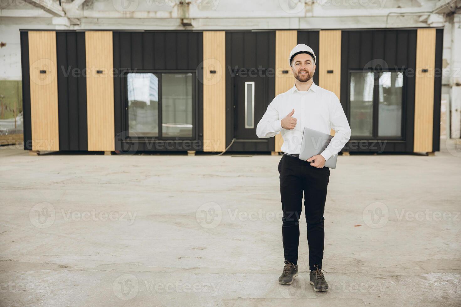 Architect gesturing thumbs up in front of modular building photo