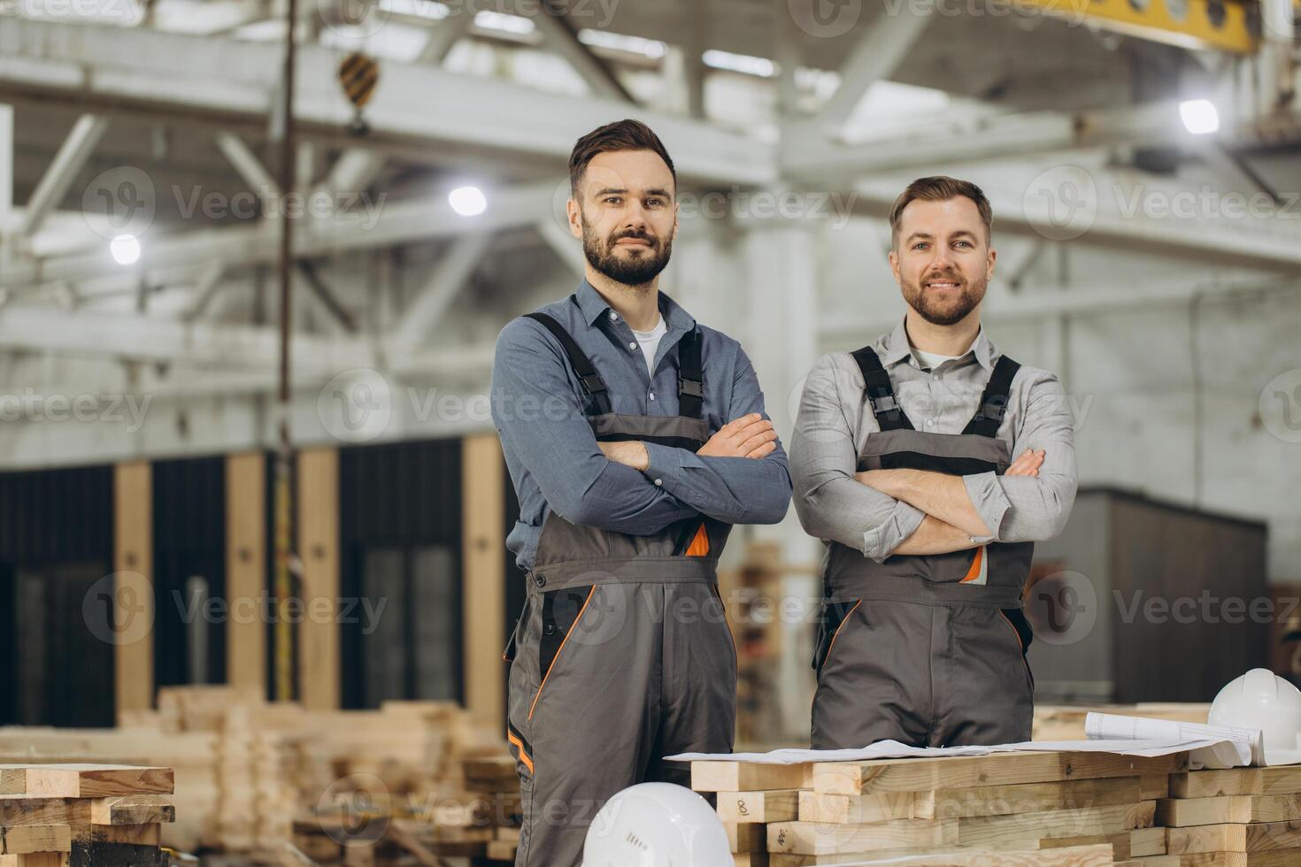 Engineers posing with arms crossed in modular building factory photo