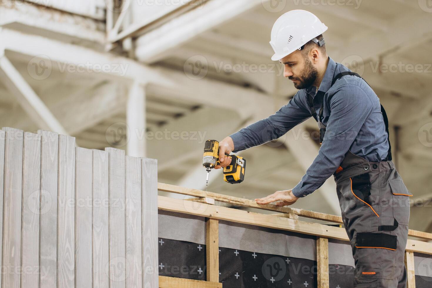 Construction worker building prefabricated modular house using cordless screwdriver photo