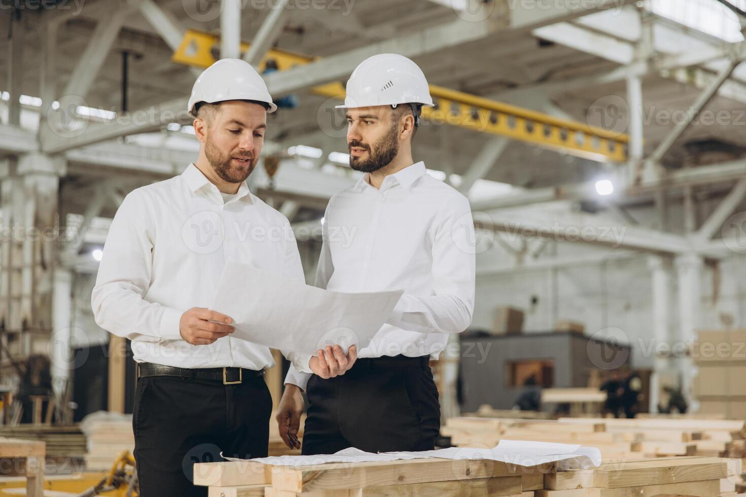 Engineers discussing plans in modular building factory photo