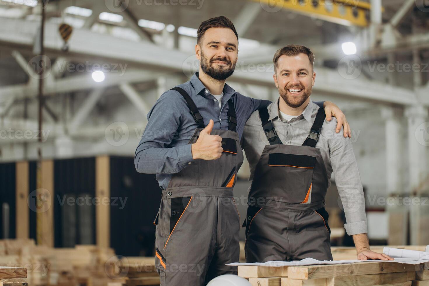 Engineers smiling and giving thumbs up in modular building factory photo