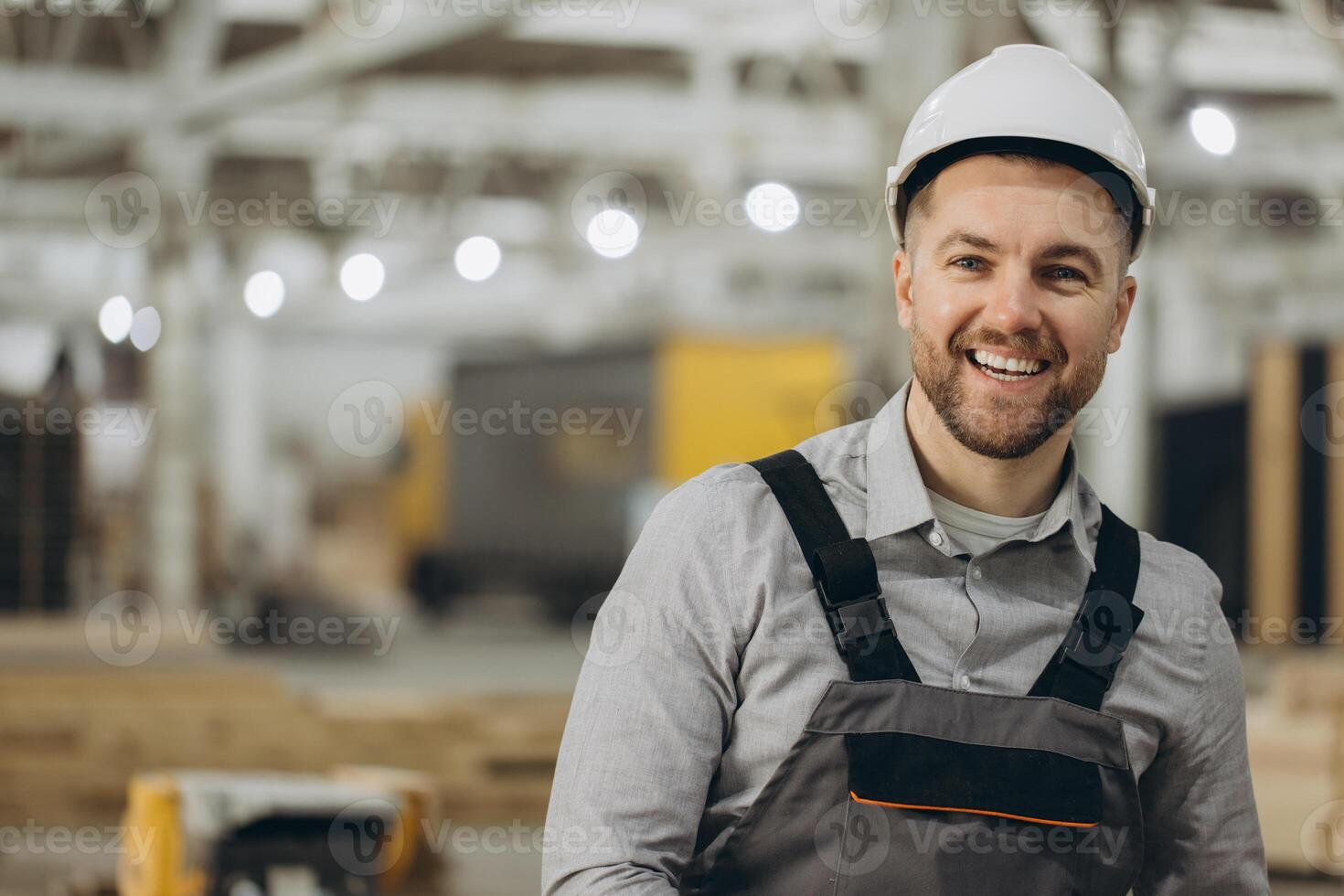 Smiling engineer wearing hardhat in modular building factory photo