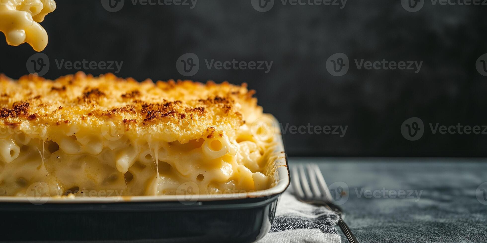 Serving of mac and cheese being plated from a large dish, meal photography photo