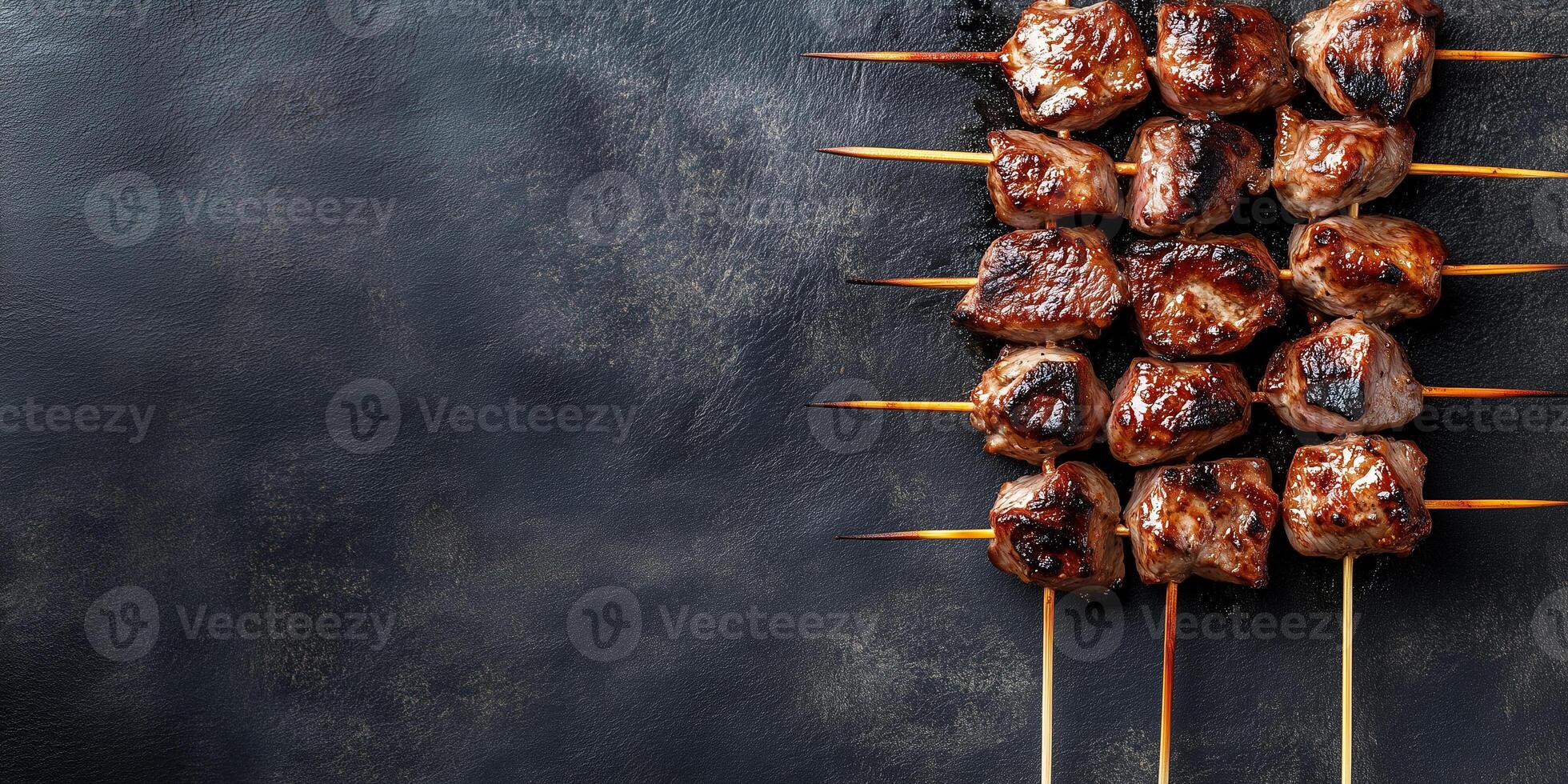 Skewer with small grilled meat pieces, evenly spaced, lying on a flat surface, gastronomy photography photo