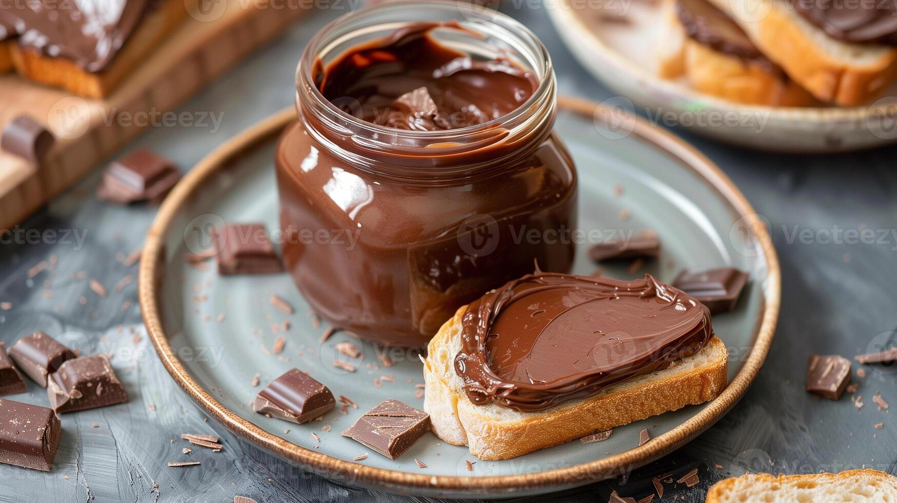 Jar of chocolate spread with a portion spread on a slice of bread on a plate, food setting photo
