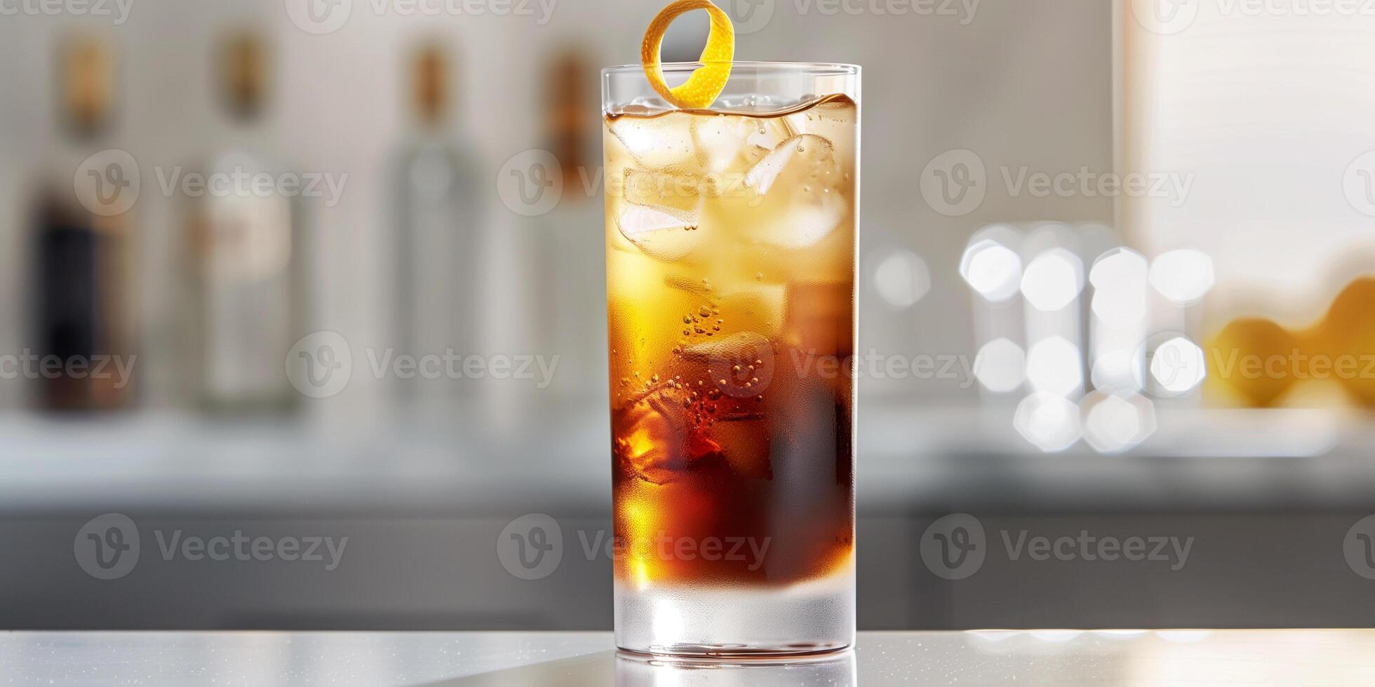 Tall glass with layers of clear and brown liquids, garnished with a lemon twist, food setting photo