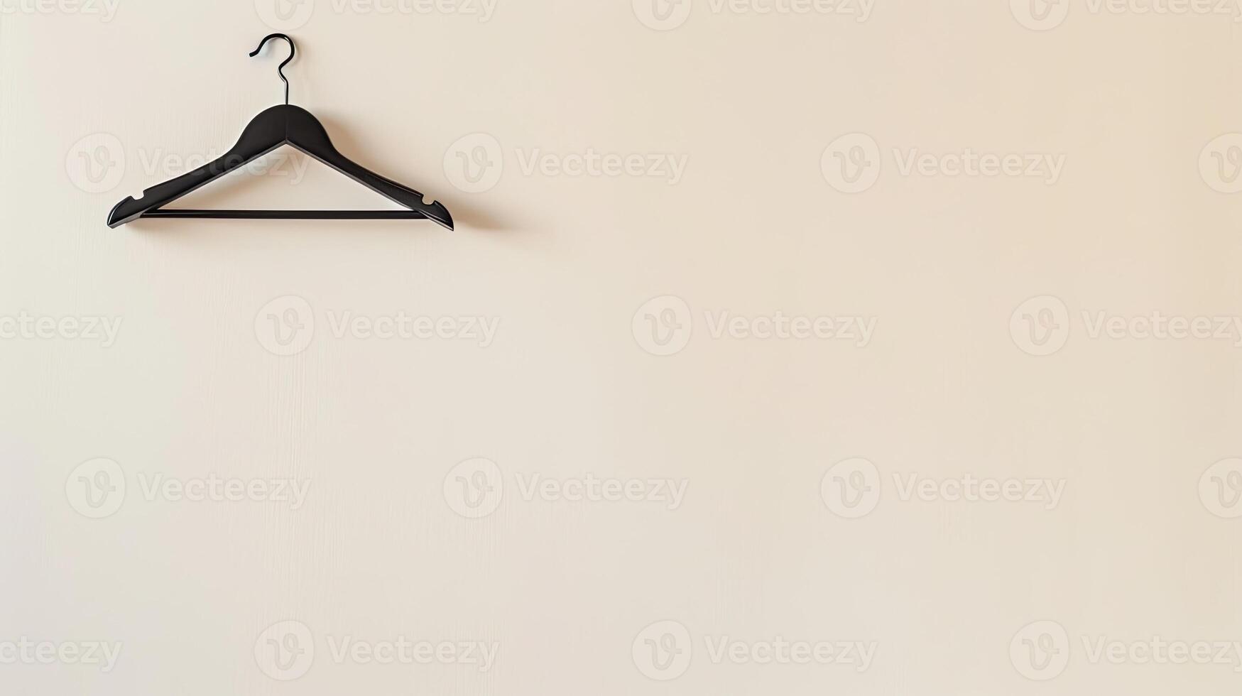 A black hanger on a white wall photo