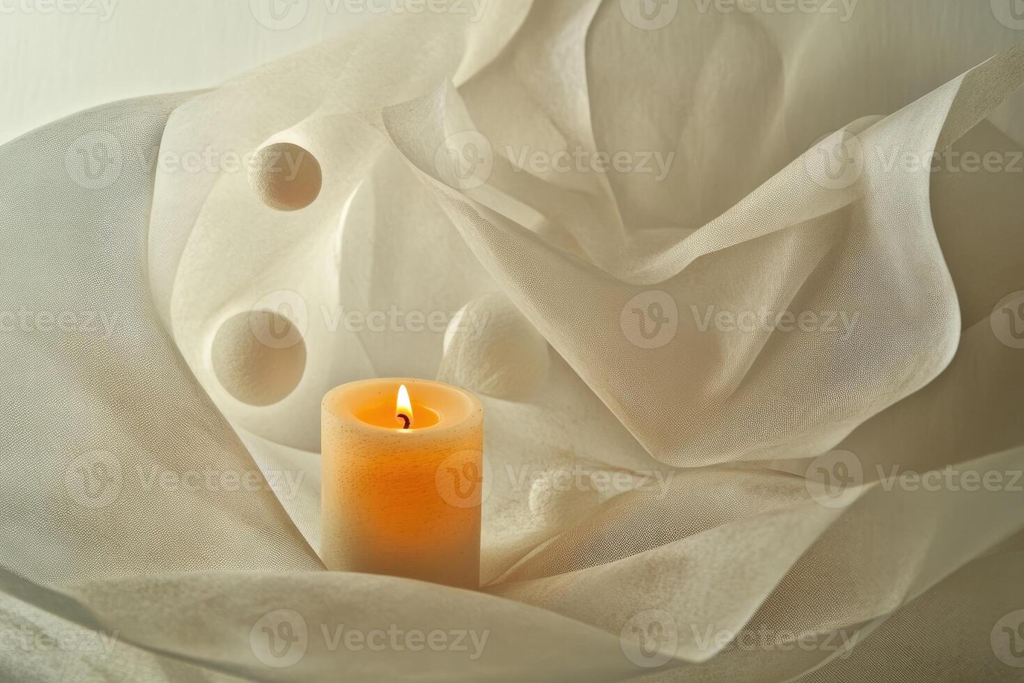 A Lit Candle Nestled in Creamy Draped Fabric photo