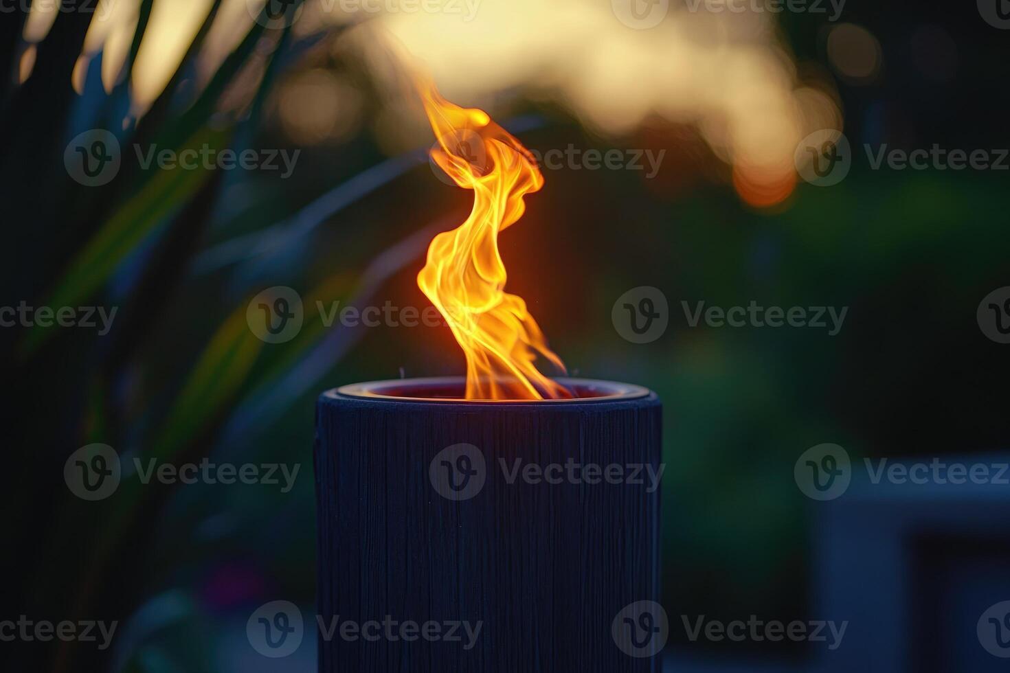 A Single Flame Burning in a Black Cylinder at Sunset photo