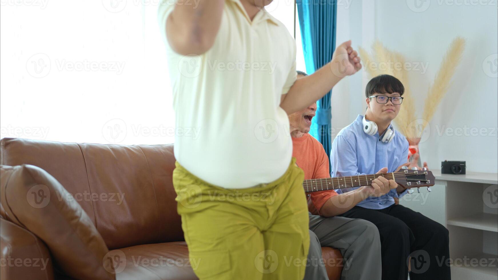 A family with an autistic child enjoys singing and dancing together at home during the holidays photo