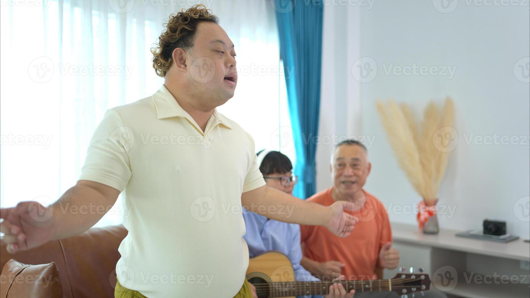 A family with an autistic child enjoys singing and dancing together at home during the holidays photo